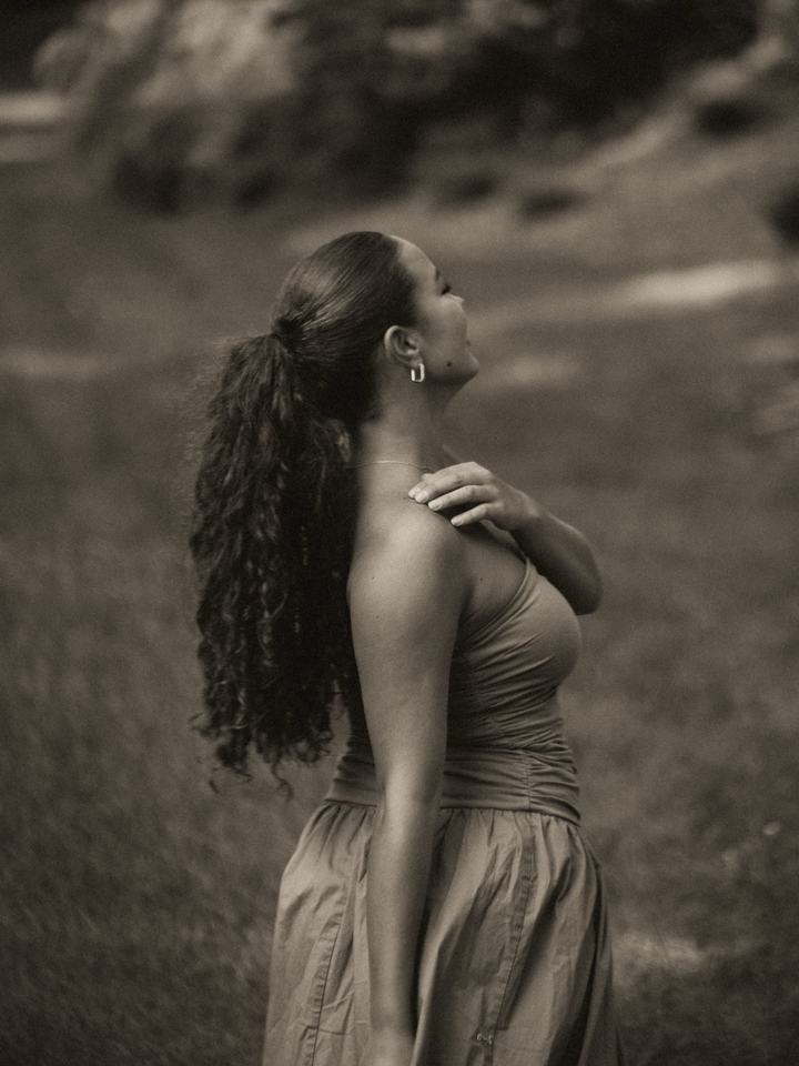 Woman looking up into the light, hand on her shoulder
