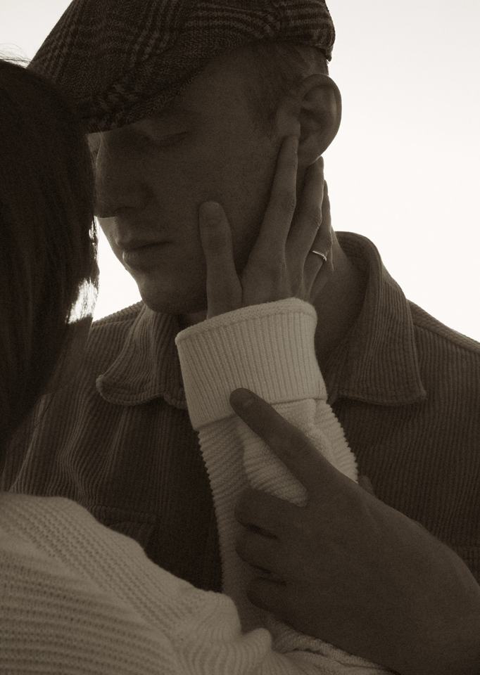Her hand on his face, warm backlight