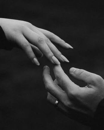 Two hands reaching for each other in black-and-white